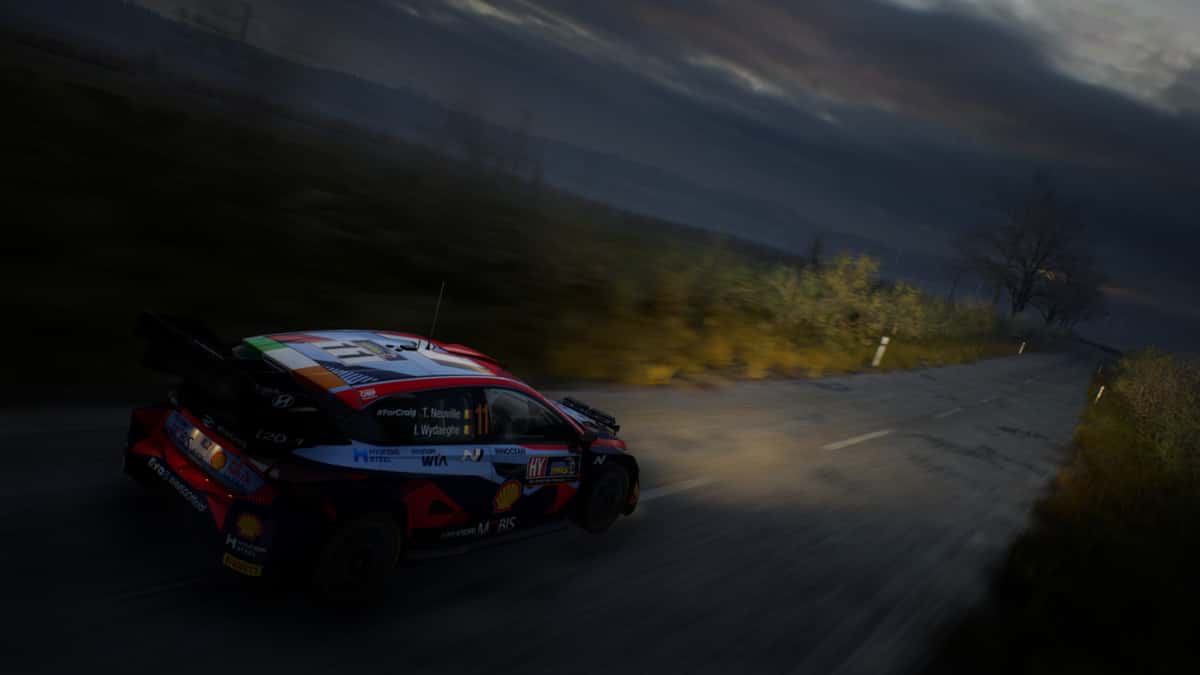 Car racing at night with headlights on in EA Sports WRC