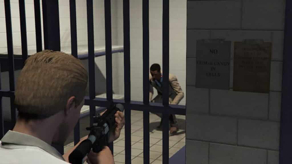 GTA Online player aiming at enemy in jail cell.