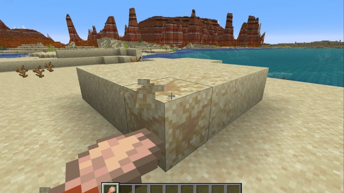 A player breaking suspicious sand blocks in Minecraft.