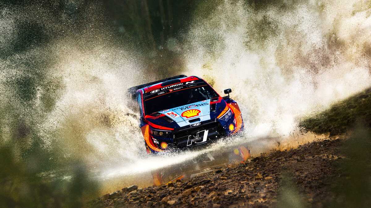 Rally car driving fast and sploshing water from the river in EA Sports WRC